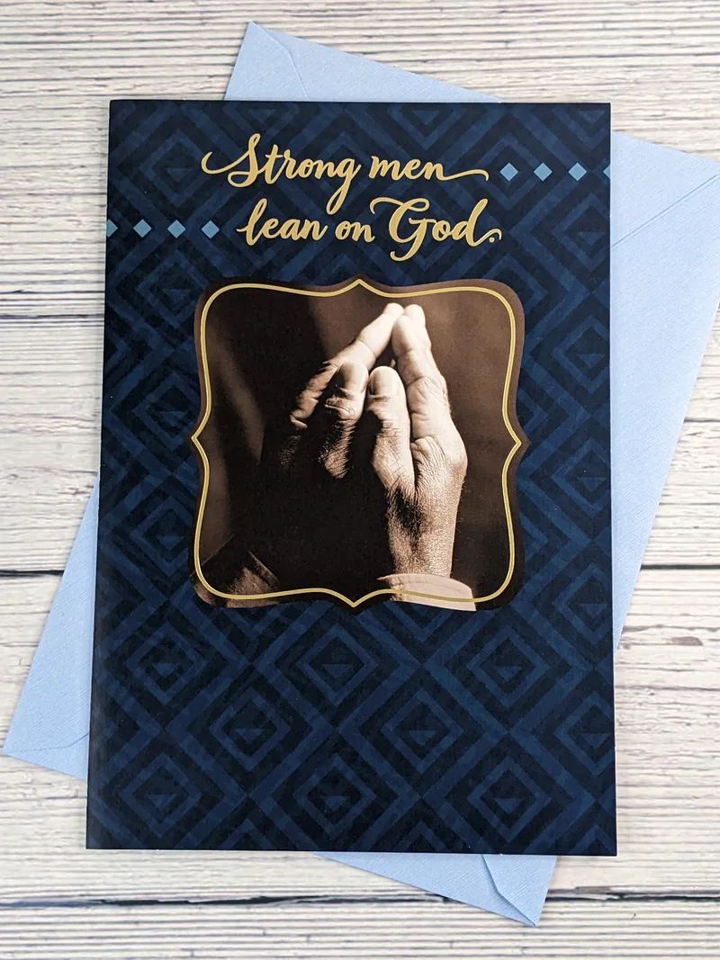 A religious Father's Day card with an image of praying hands on a navy-blue background.