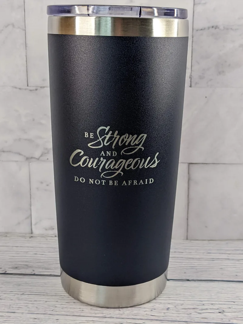 A stainless-steel travel mug with a blue exterior, featuring a Bible verse: Be strong and courageous.