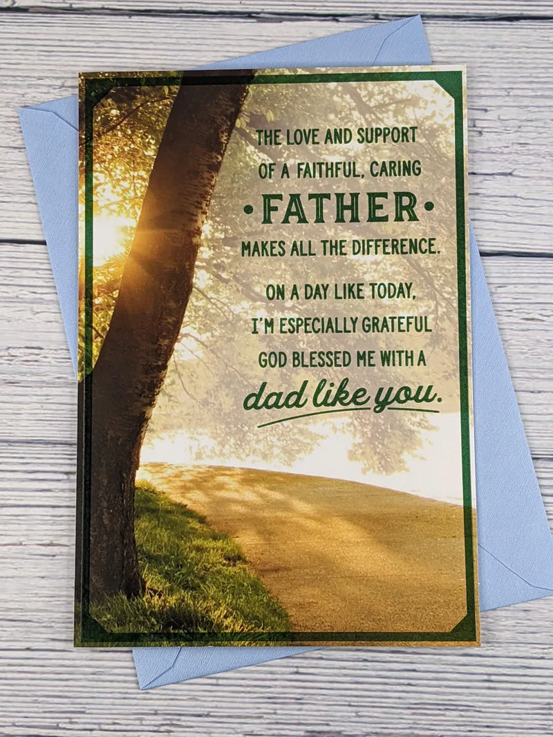 A religious Father's Day greeting card with embossed letters and an image of a tree in the sunlight.