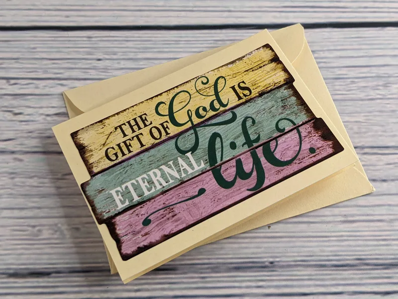 A mini greeting card with an envelope, cream colored with the Bible verse, "The gift of God is eternal life."