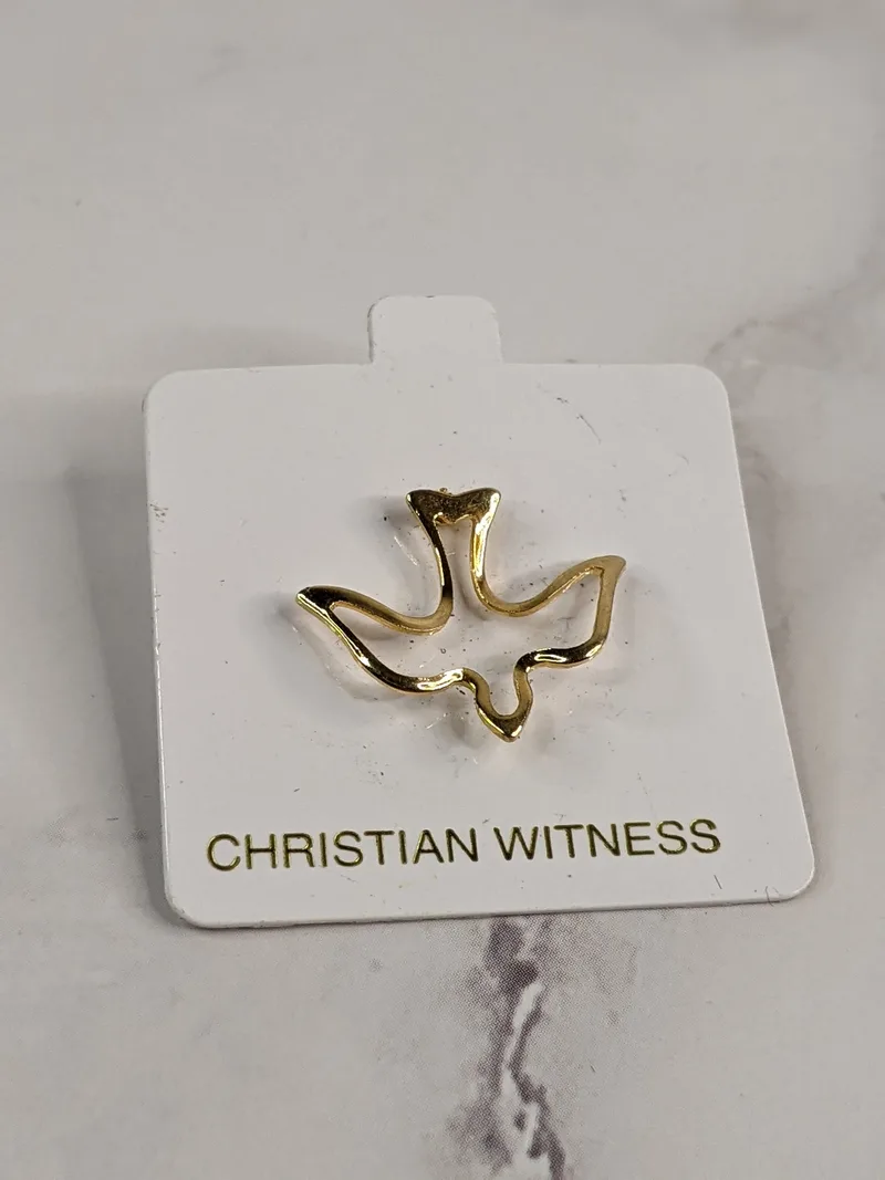 A gold lapel pin that is shaped like an outline of a dove, clipped onto a white tag that says, "Christian Witness."