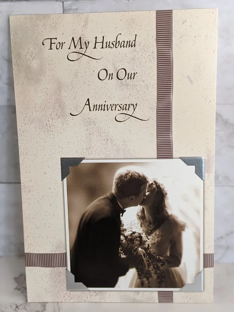 An anniversary greeting card with a religious message, for a wife to give to her husband, with an image of a couple.