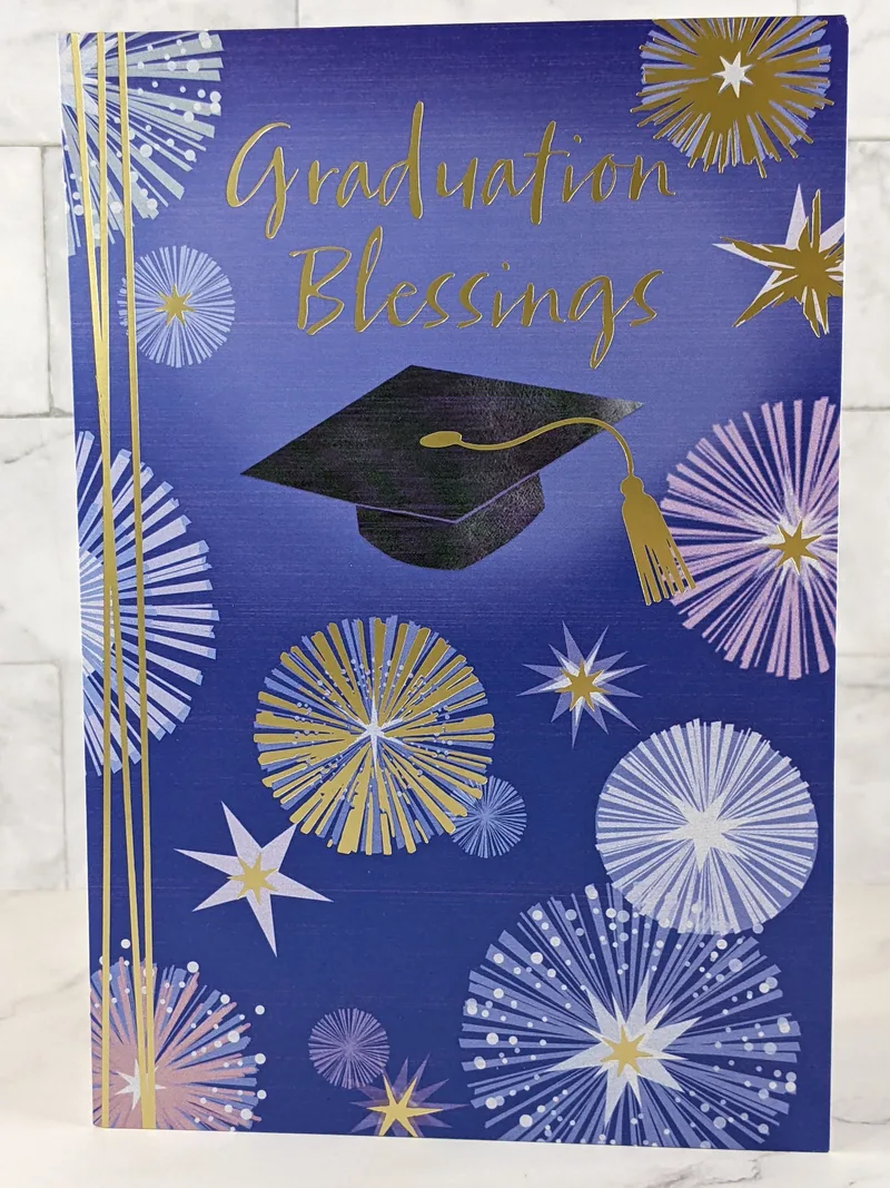A graduation card with a blue background that has images of fireworks and a graduation cap.