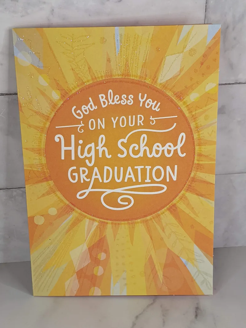 A religious high school graduation card with a glittery image of an orange and yellow sunshine.