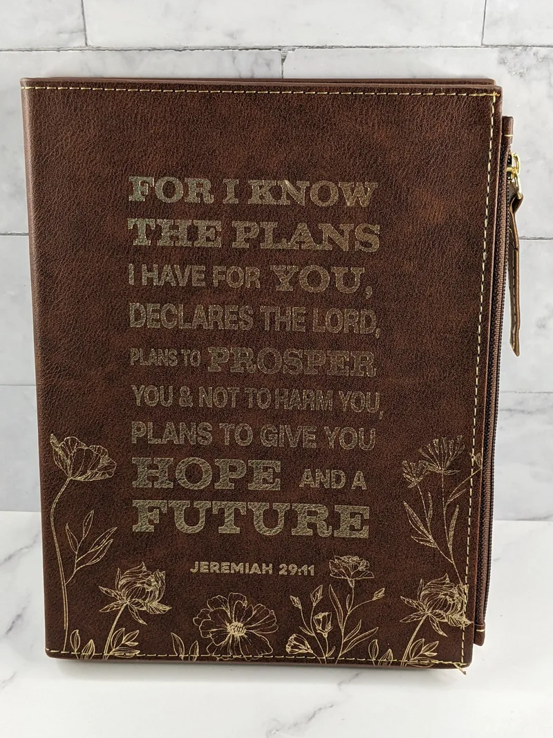 A brown faux leather covered journal with a Bible verse on the cover (Jeremiah 29:11) and a zippered pocket.