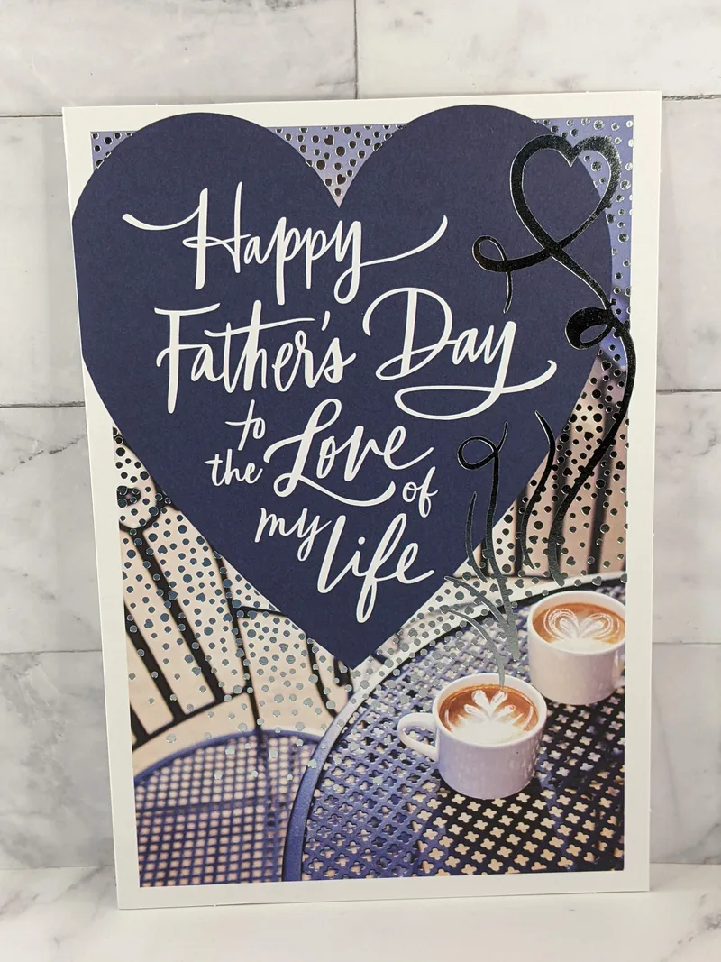A Father's Day greeting card for a husband from a wife. The image on the cover is of two lattes and a navy blue heart.