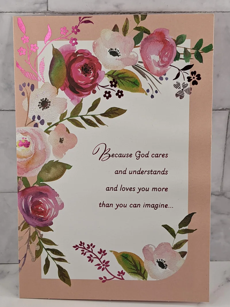 A Christian "praying for you" greeting card with pink flowers on the cover.