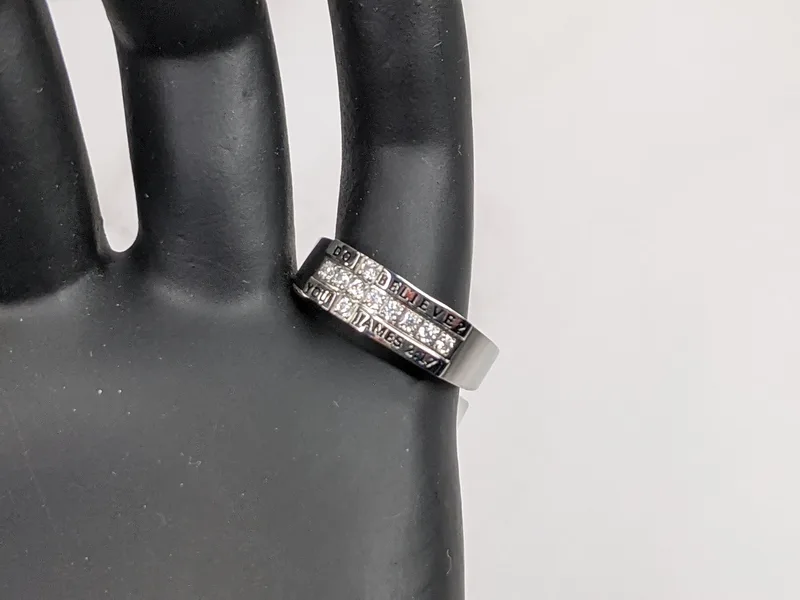 A women's silver religious ring with a rhinestone cross design and a Scripture reference.