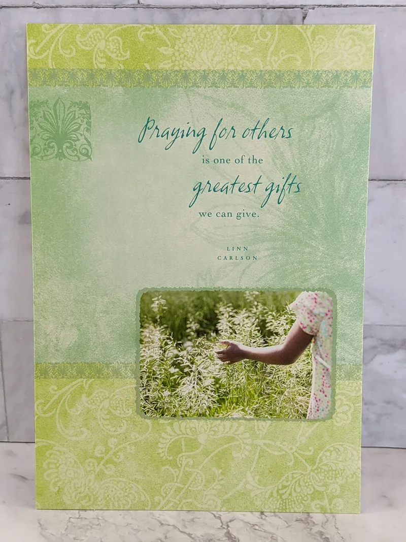 An encouragement greeting card with a green cover, featuring an image of a garden and a Christian message about prayer.