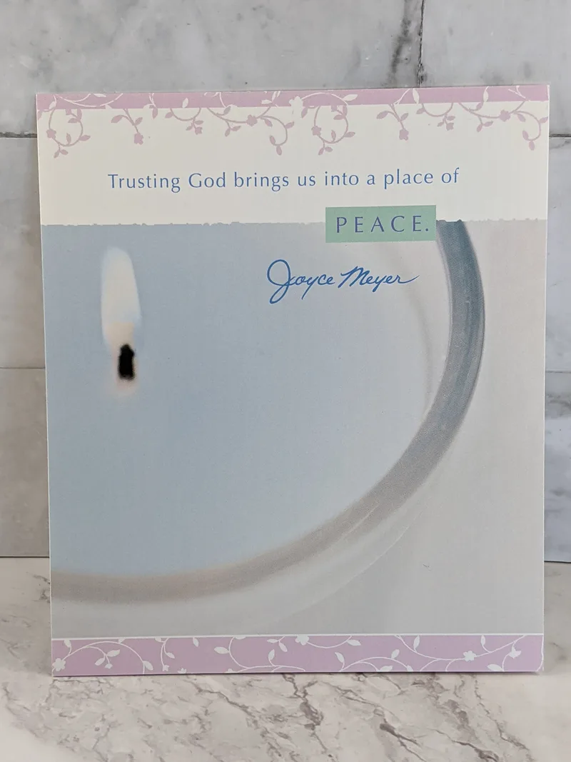 A greeting card with an image of a blue lit candle and a Christian encouragement message by Joyce Meyer.