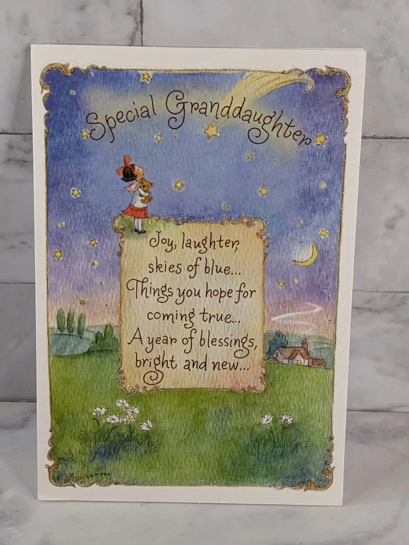 A Christian birthday greeting card for a granddaughter, with a religious message and an image of a girl hugging a teddy bear.