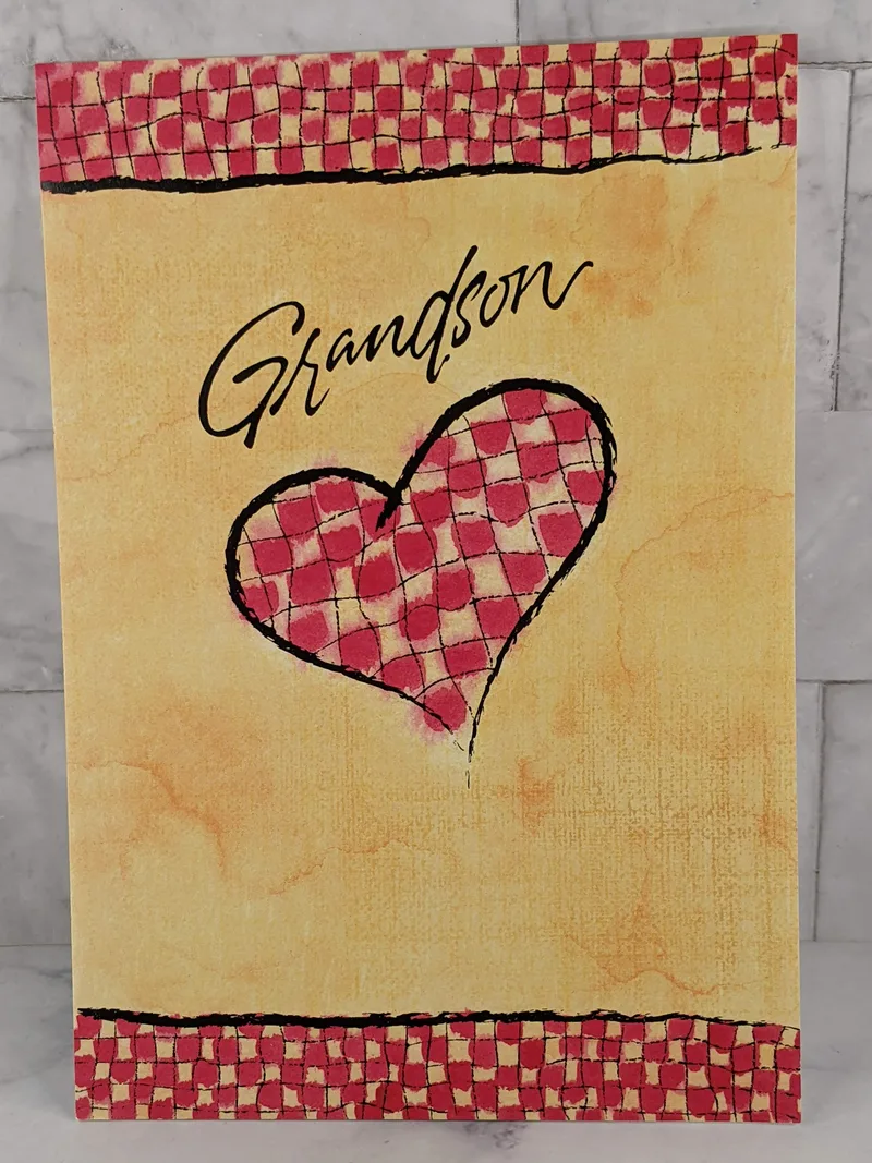 A Christian Valentine greeting card for a grandson with a golden colored cover with a red checkered heart.